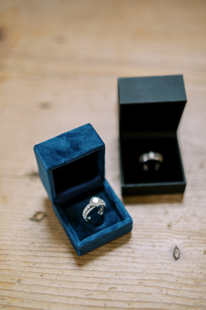 Wedding rings lie in boxes on a wooden table