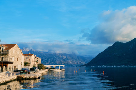 Ancient stone houses on the shore of Perast against the backdrop of mountains in the sun. Montenegroの写真素材