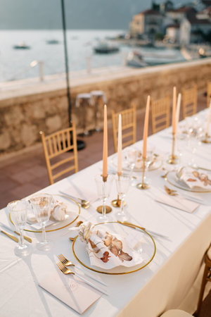 Knotted napkins lie on plates on a holiday table next to invitationsの写真素材