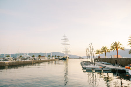 Long parallel piers with moored rows of yachts against the backdrop of mountains at sunset