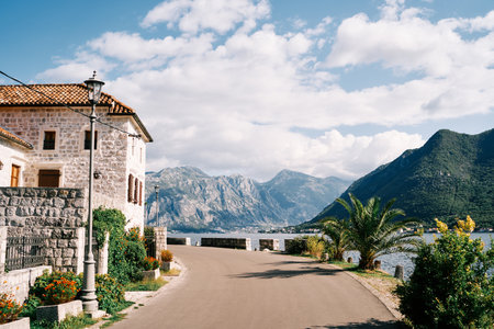 Old stone mansion with a green garden at the turn of the road above the sea. Perast, Montenegroの写真素材