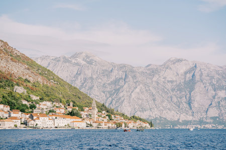 Ancient houses of Perast on the shore of the Bay of Kotor with an ancient bell tower against the backdrop of the mountains. Montenegroの写真素材