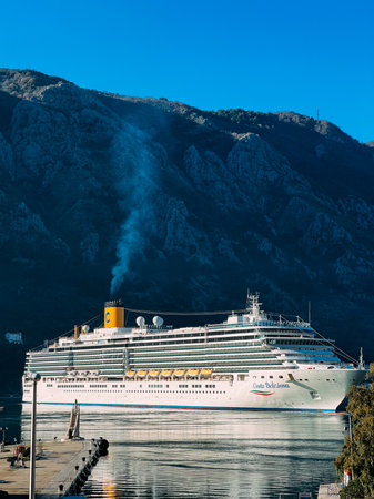 Kotor, Montenegro - 25 december 2022: Huge white cruise ship at the pier against the backdrop of the mountainsのeditorial素材