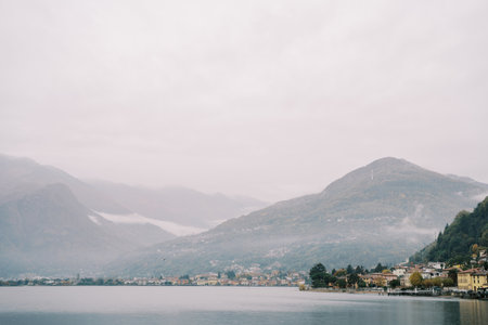 Misty mountains on the coast of Lake Como with luxury villas. Italy