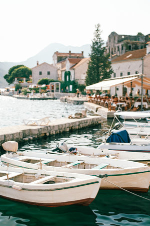 White wooden fishing boats are moored at the pier. Perast, Montenegro