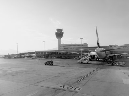 Afines, Greece - 20 august 2023: Plane stands with a ladder in front of the airport building. Back view. Black and white photoのeditorial素材