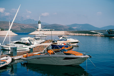 Motor yachts are moored at the pier in Lustica Bay near the lighthouse. Montenegro
