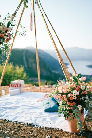 Bouquet of flowers in a vase stands at the wedding arch wigwam on a mountain above the Bay of Kotor. Montenegroの写真素材