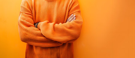 Person in orange sweater on orange background, emanating warmthの素材