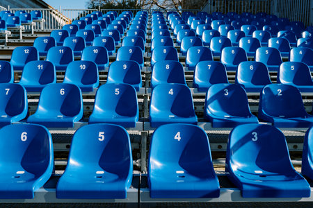 Blue numbered seats are arranged in tiers in the stadiumの写真素材