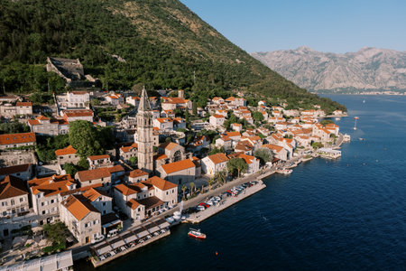 Bell tower of the Church of St. Nicholas among the red roofs of ancient houses on the shore of the Bay of Kotor. Perast, Montenegro. Droneの写真素材