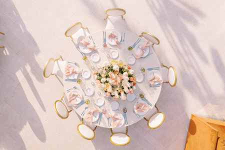 Festive round table with chairs stands in an open area. Top view