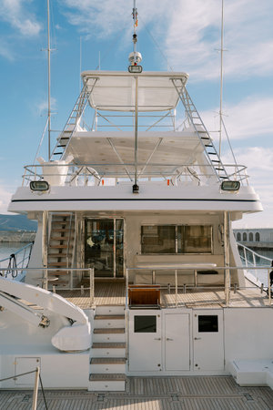 Steps aboard a white double-deck yacht