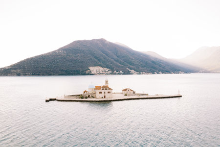 Island of Gospa od Skrpjela in the Bay of Kotor against the backdrop of sunny mountains. Montenegro. Droneの写真素材