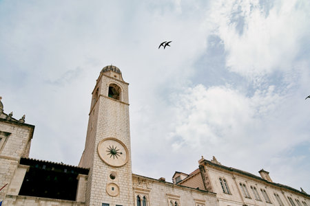Ancient stone clock tower against a cloudy sky. Dubrovnik, Croatia. High quality photo