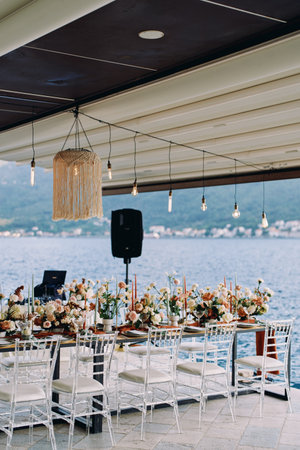 Long festive table stands on a pier by the sea. High quality photoの写真素材