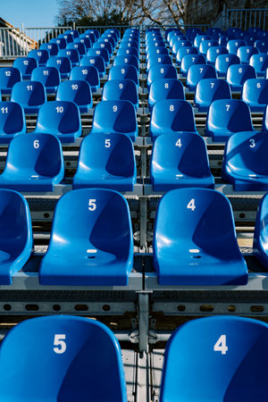 Numbered rows of blue seats go up in a stadiumの写真素材