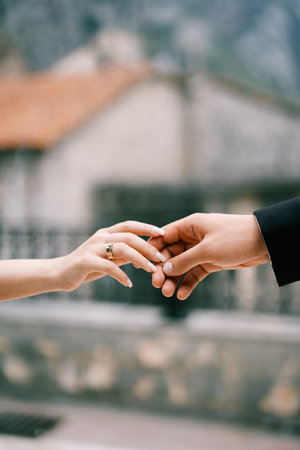 Bride hand touches groom hand. Cropped. Facelessの写真素材