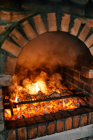 Ribs are grilled on a grid on a fire in a brick ovenの写真素材