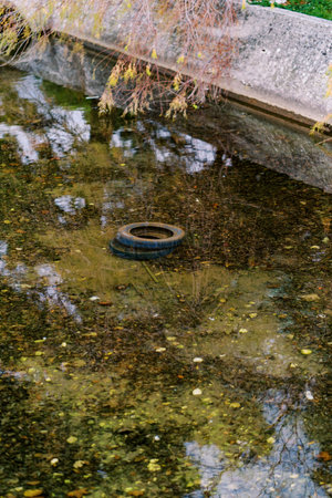 Tires are lying in the creek under the bridgeの写真素材