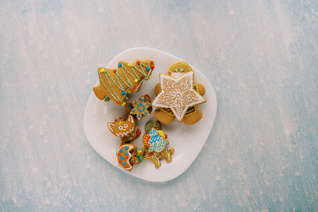 White plate with colorful gingerbread on a blue scratched backgroundの写真素材