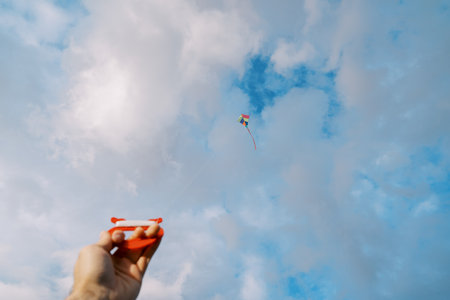 A kite flying in a cloudy sky in a handの写真素材