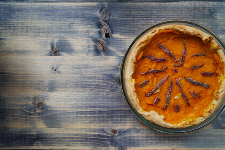 Pumpkin pie in a glass bowl on a wooden table. Top viewの写真素材