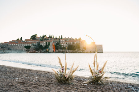 Wedding semi-arch stands on the seashore with the island of Sveti Stefan in the background. Montenegroの写真素材