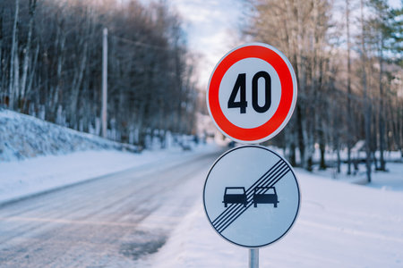 Road sign with speed limit on a snowy road in the park. Caption: 40の写真素材
