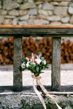Wedding bouquet stands near a wooden benchの写真素材
