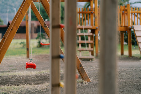 Wooden playground with swings, slides and climbing wallsの写真素材