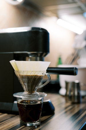 Coffee being filtered in a pour over coffee machine on the tableの写真素材