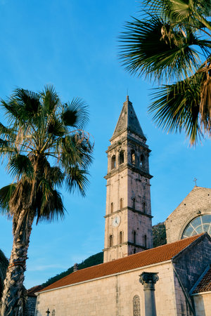 Spire of the bell tower of the Church of St. Nicholas against the blue sky. Perast, Montenegroの写真素材
