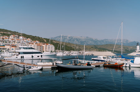 Inflatable motor boats stand next to yachts at the marina berthsの写真素材