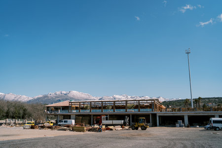Trucks stand near a warehouse with boards at the foot of the mountainsの写真素材