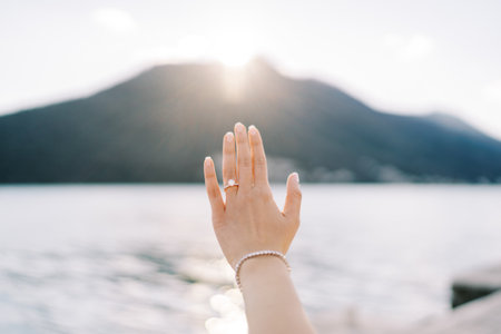 Wedding ring on an outstretched woman arm against the backdrop of mountains. Croppedの写真素材