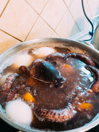 Whole squid is cooked in a pot on the stoveの写真素材