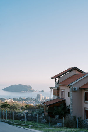 Two-storey house on a mountainside in a town above the seaの写真素材