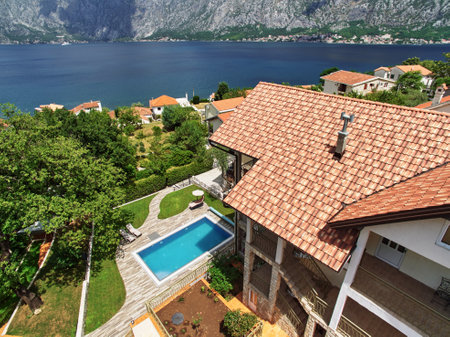 Rectangular swimming pool in the courtyard of the villa overlooking the sea and mountains. Droneの写真素材