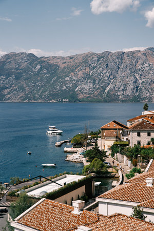 Small yacht approaches the pier of a resort town