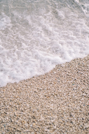 Sea surf rolls onto the pebble beachの写真素材