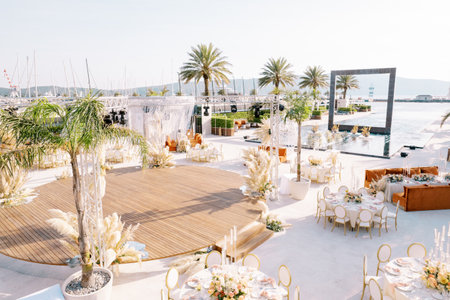 Round served tables stand near the stage on the marina embankmentの写真素材
