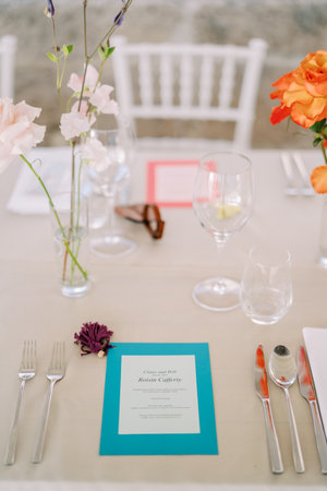 Bright personalized invitation lies on the festive table next to a bouquet of flowers