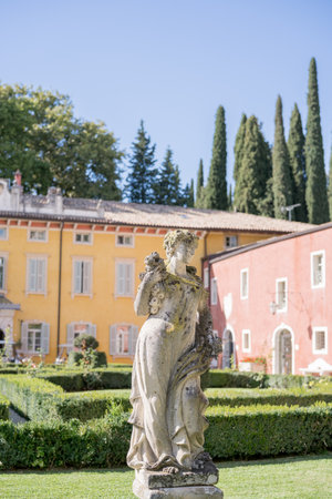 Sculpture of a woman on a pedestal in the garden of an ancient villaの写真素材