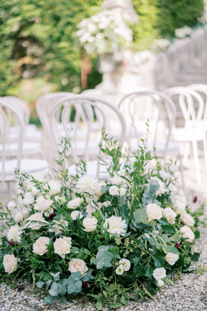 Large bouquet of flowers stands near white chairs in the parkの写真素材