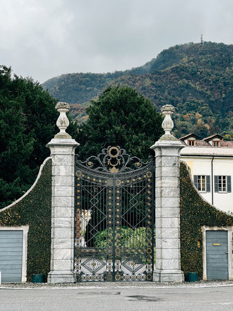 Forged openwork gate at the entrance to an old villa in a green gardenの写真素材