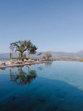 Sun loungers and sun umbrellas stand by the pool. Greece