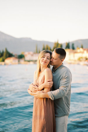 Man hugs woman from behind while standingの写真素材