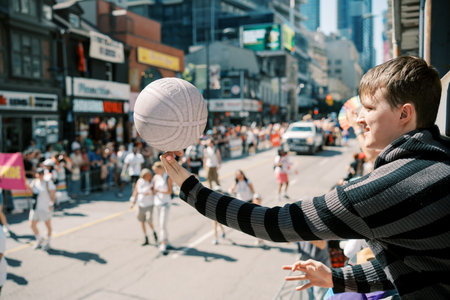 Toronto, Canada - June 29, 2025: White teen spectator catching balloon at Toronto Pride