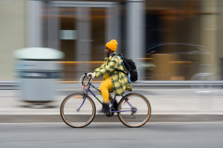 Toronto, Canada - May 12, 2026: Urban cyclist in yellow plaid jacket riding through Toronto streets